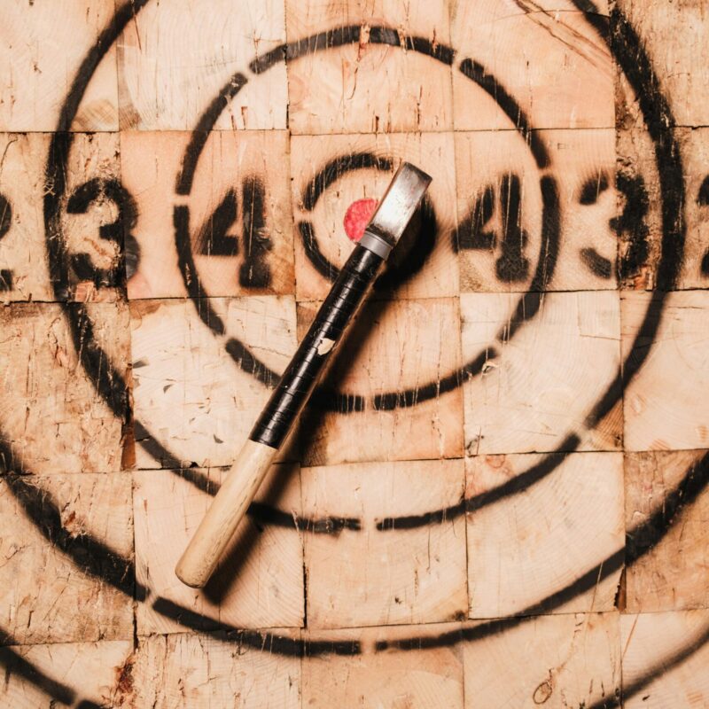 Axe in a target board highlighting bullseye focus and precision in axe throwing.